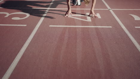 Front-view-of-a-female-athlete-starting-her-sprint-on-a-running-track.-Runner-taking-off-from-the-starting-blocks-on-running-track.-Zoom-camera.-Slow-motion